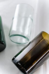 Close-up of colored glass bottles on a white surface, featuring a modern artistic arrangement.