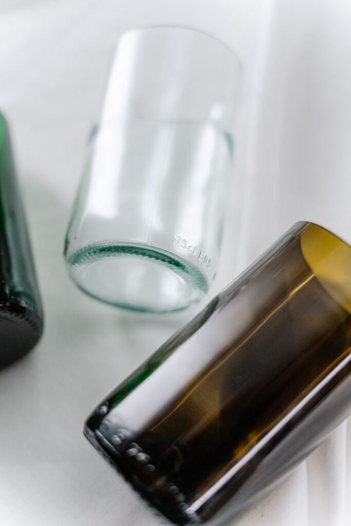 Close-up of colored glass bottles on a white surface, featuring a modern artistic arrangement.